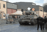 a group of people watching a tank with the number 34 on the side