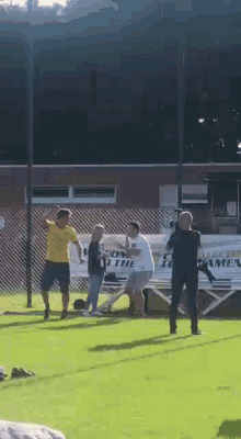 a group of people standing on a soccer field with a sign that says ' soccer for men ' on it