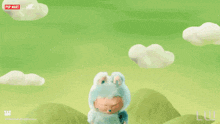 a stuffed animal is sitting on top of a grassy hill with a pop mart logo in the background