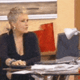 a woman is sitting at a desk with a laptop computer .