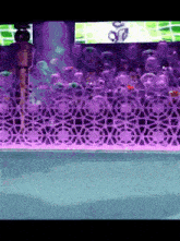 a woman in a bikini stands in front of a purple and white wall