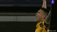 a man in a yellow shirt with the letters tg on it