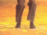 a close up of a person 's legs walking on a yellow surface