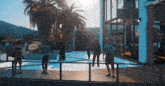 a group of people standing in front of a building with a palm tree