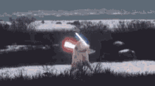 a person is holding a light saber in a field of snow .
