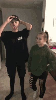 a boy wearing a t-shirt that says ' nirvana ' sticking his tongue out next to a girl