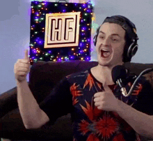 a man wearing headphones giving a thumbs up in front of a sign that says hf on it