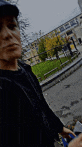 a man in a black shirt is standing in front of a building that says ' a ' on it