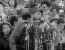 a man is speaking into a microphone that says progress