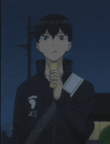 a young boy wearing a black jacket with ics on it