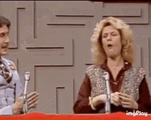 a woman with blonde hair is making a funny face while talking into a microphone .
