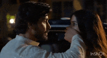 a man is touching a woman 's face with his hand .