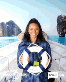 a woman holding a life preserver in front of a bravo con sign