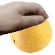a close up of a hand holding a yellow fruit
