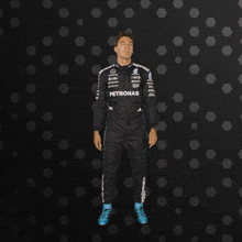 a man in a petronas suit is standing on a black background