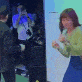 a man is taking a picture of a woman dancing in front of a crowd .