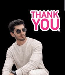 a man wearing sunglasses stands in front of a thank you sign