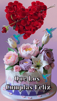 a birthday cake with flowers and hummingbirds and the words " que los cumplas feliz " on the bottom