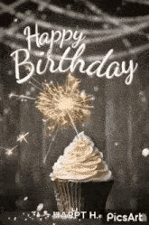 a happy birthday greeting card with a cupcake and a sparkler .