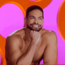 a shirtless man with a beard is smiling