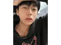 a close up of a person 's face with a necklace and a black shirt with a fox on it