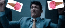 a man in a suit and tie is holding up two ice cream cones with pink scoops on them