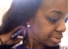a close up of a woman 's face with a phone in her ear