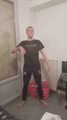 a man wearing a black balmain t-shirt is dancing