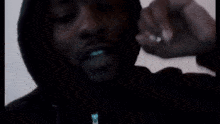 a close up of a man wearing a black hoodie and smiling .