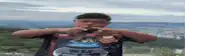 a boy wearing a nerf shirt is making a heart shape with his fingers
