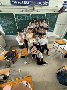a group of students are posing for a picture in front of a chalkboard that says le toi ket