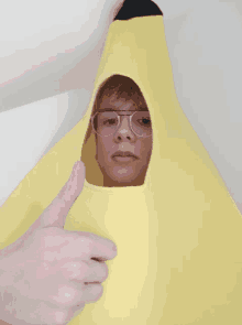 a person wearing a banana costume is giving a thumbs up