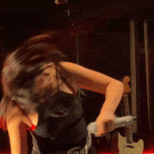 a woman in a black top is dancing on a stage