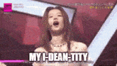 a woman is singing a song on a stage and the words `` my l-dean-tity '' are on the screen .