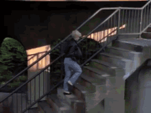 a person is walking up a set of stairs with a railing .