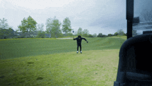 a man is standing on a golf course with a golf club