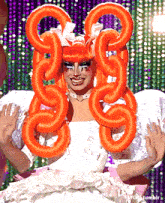 a woman in a white dress with orange balloons in her hair is being photographed by tumblr