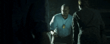 a man in a blue shirt has a badge around his neck with the letter c on it