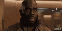 a close up of a man with a beard and a netflix logo on the bottom