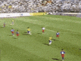 a soccer game is being played on a field with a crowd in the stands