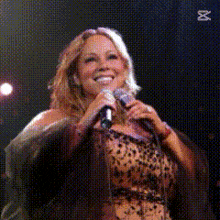a woman singing into a microphone with a x on the bottom