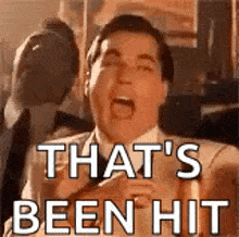 a man in a suit and tie is making a funny face and says `` that 's been hit '' .