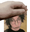a hand is holding a piece of paper over a person 's face .