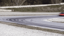 a red sports car is driving on a track