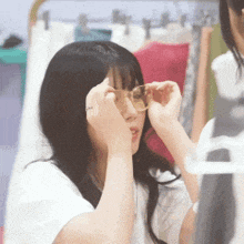 a woman wearing sunglasses is looking at herself in a mirror
