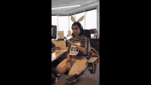 a woman wearing bunny ears and a sign that says gif on it