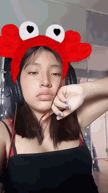 a girl wearing a crab headband and headphones looks sad