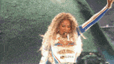 a woman singing into a microphone wearing a shirt that says love