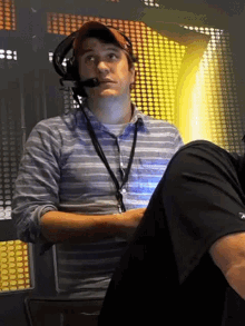 a man wearing a headset and a lanyard with the word a on it