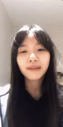 a young woman with long black hair is smiling for the camera